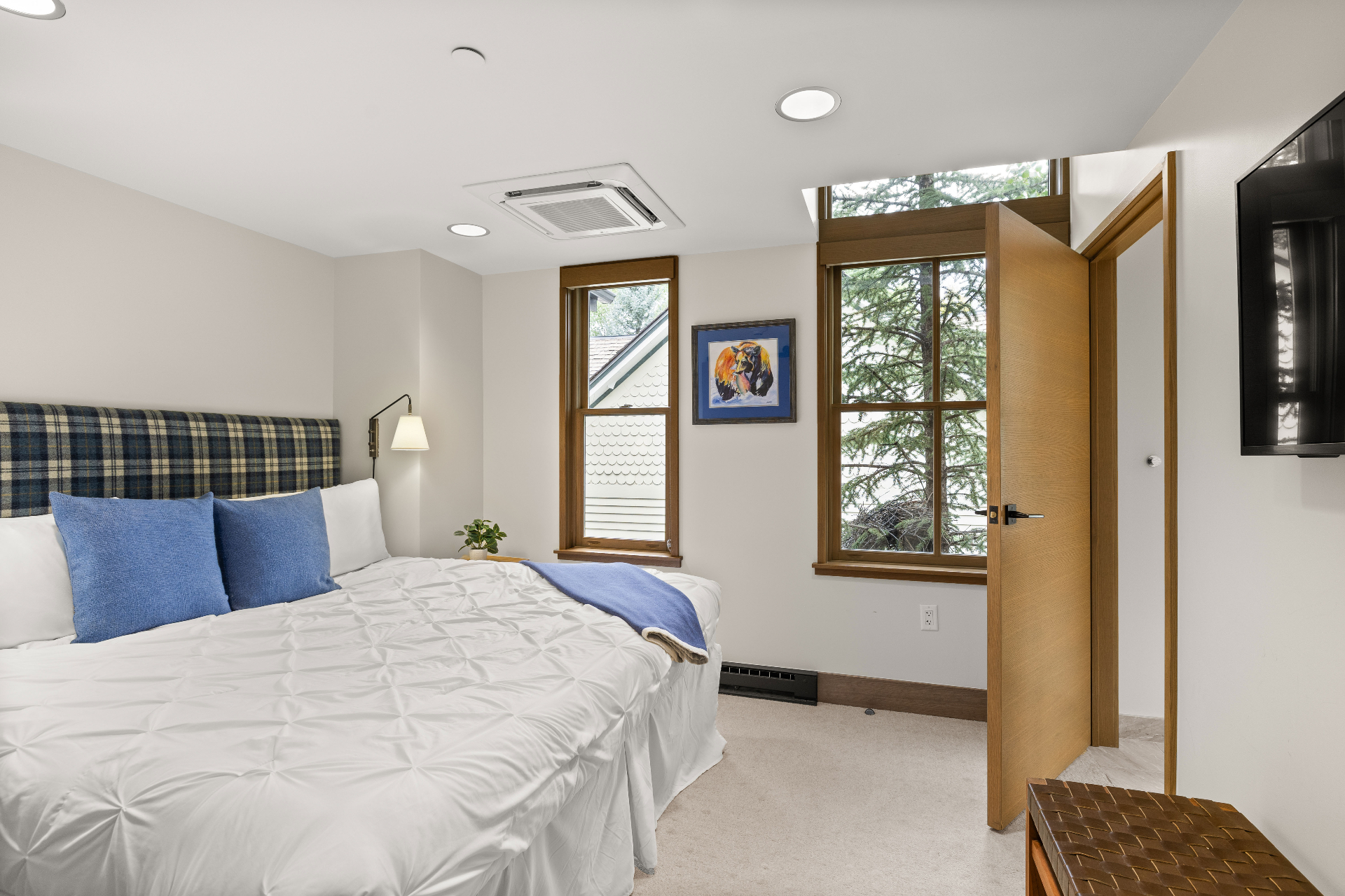 Cozy bedroom with plaid headboard and mountain art